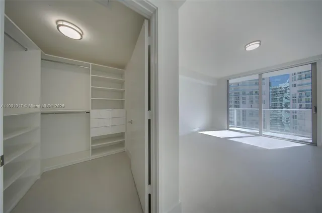 a view of empty room with wooden floor and windows