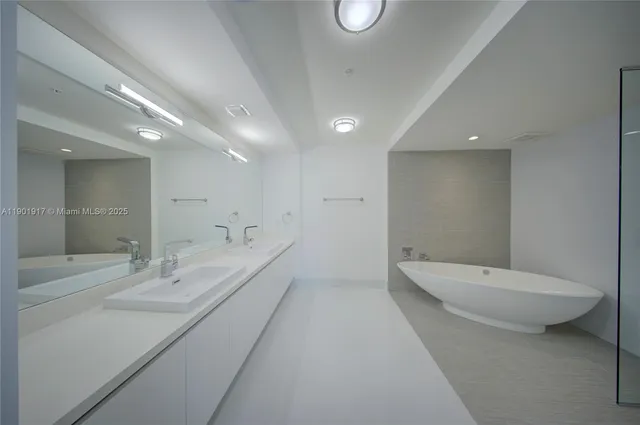 a bathroom with a double vanity sink toilet and a mirror