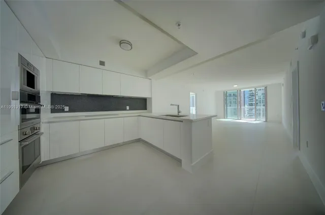 a kitchen with white cabinets and white appliances