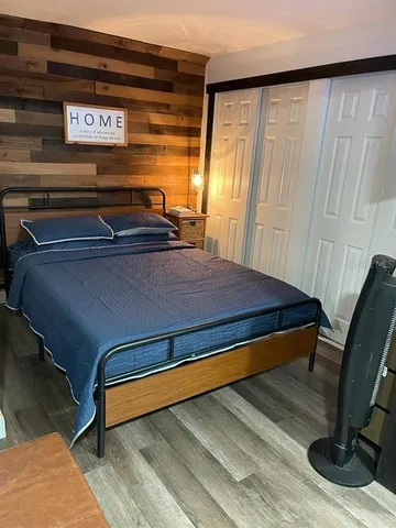 a bedroom with a bed and wooden floor