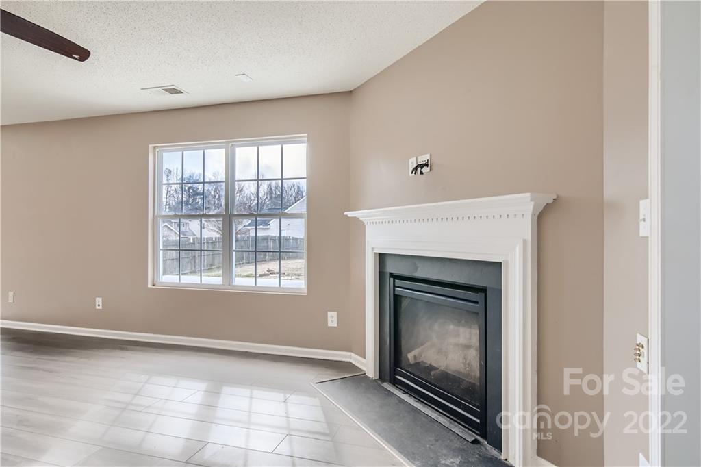 7005 Copper Ridge Court Gastonia, NC 28056 - Photo 6 of 33 a view of an empty room with a fireplace and a window