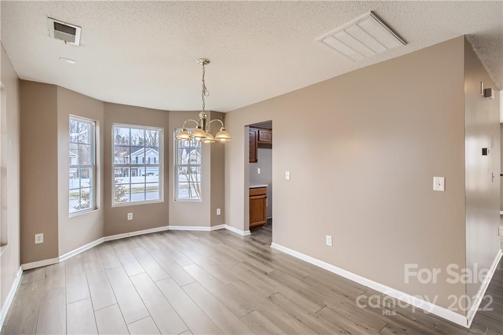 7005 Copper Ridge Court Gastonia, NC 28056 - Photo 7 of 33 a view of an empty room with wooden floor and a window