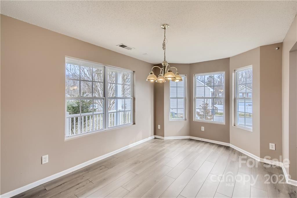 7005 Copper Ridge Court Gastonia, NC 28056 - Photo 8 of 33 a view of an empty room with wooden floor and a window