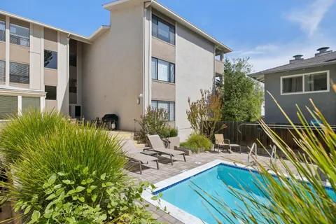 a view of a house with backyard and sitting area