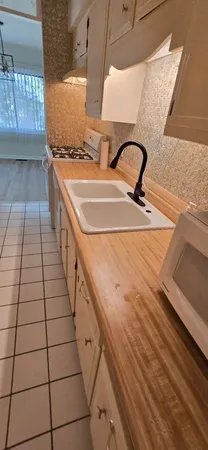 a bathroom with a granite countertop sink and a toilet