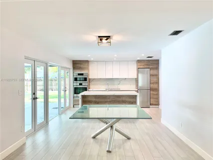 a view of kitchen with wooden floor and electronic appliances