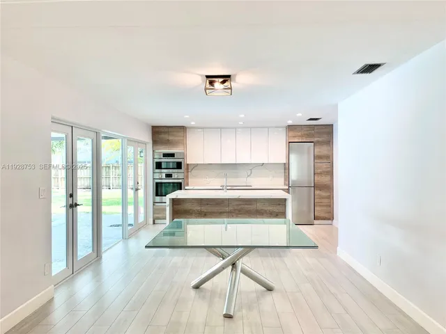 a view of kitchen with wooden floor and electronic appliances