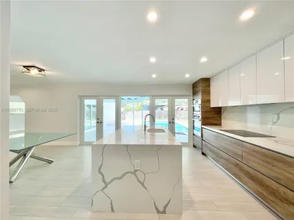 a large white kitchen with a large window