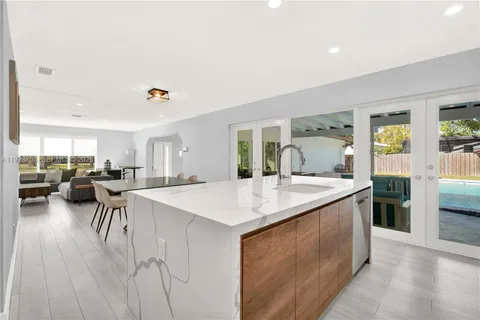 a open kitchen with stainless steel appliances granite countertop a table and chairs in it