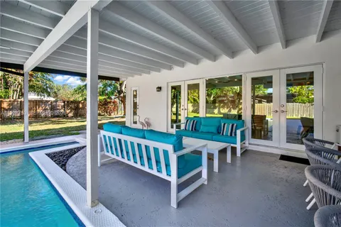 a view of a patio with a table and chairs next to a yard