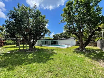 a view of a backyard with large trees