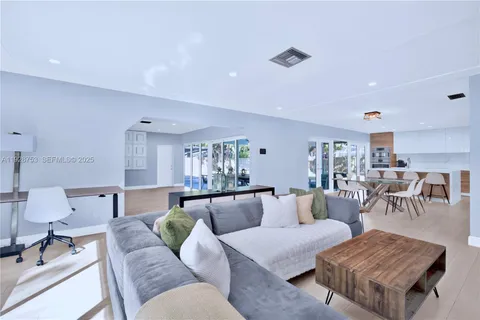 a living room with furniture and view of kitchen