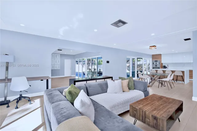 a living room with furniture and view of kitchen