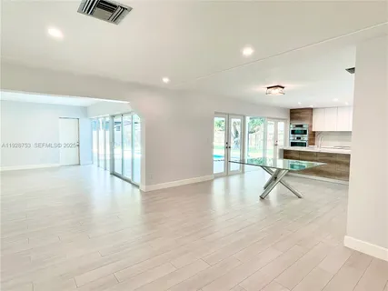 a view of empty room with wooden floor and windows