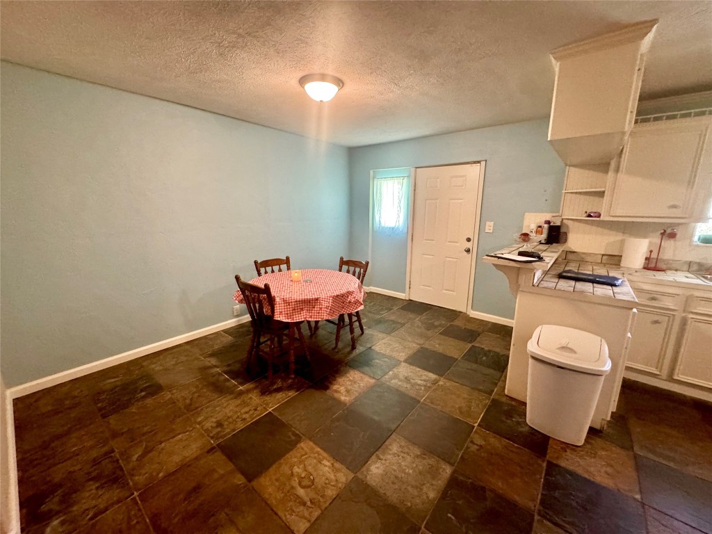 303 Charles Street Cleveland, TX 77327 - Photo 17 of 43 a kitchen with a sink and chairs