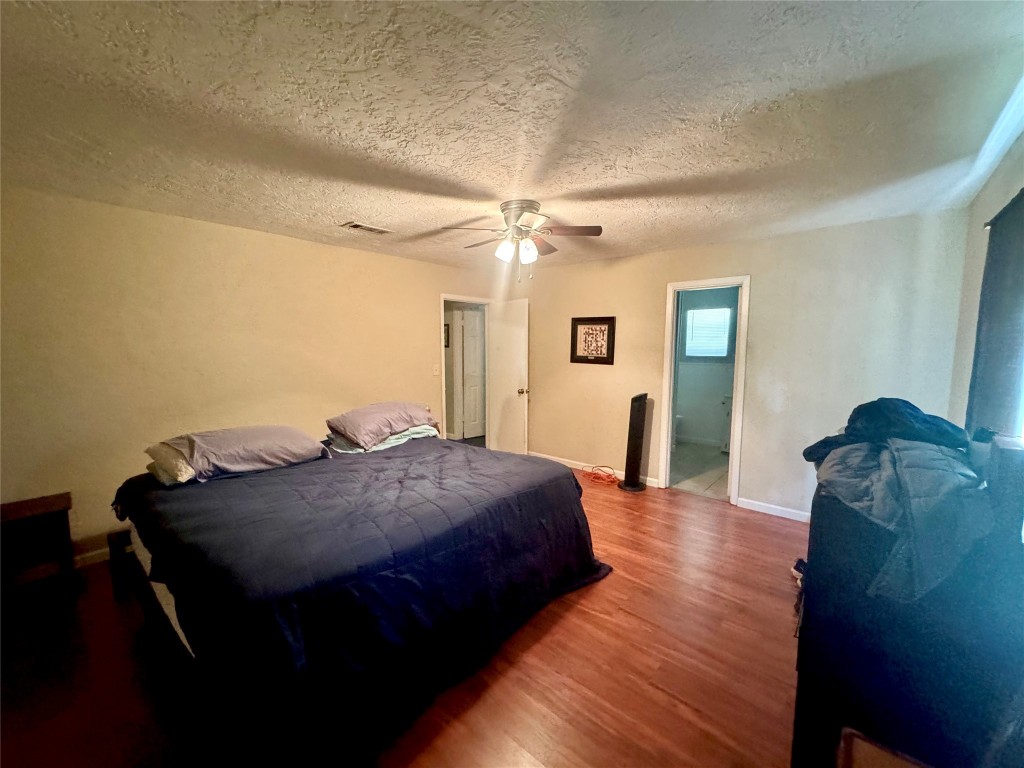 303 Charles Street Cleveland, TX 77327 - Photo 27 of 43 a bed room with a bed and a chandelier