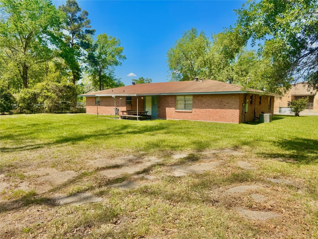303 Charles Street Cleveland, TX 77327 - Photo 9 of 43 a front view of a house with a yard and trees