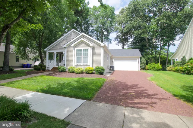 a front view of a house with a yard and trees