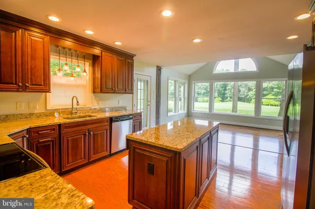 a kitchen with stainless steel appliances granite countertop a sink a stove and a refrigerator