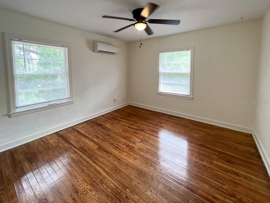 1124 Northwest 4th Avenue Gainesville, FL 32601 - Photo 13 of 16 a view of an empty room with wooden floor and a window
