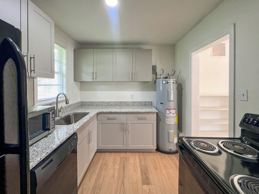 1124 Northwest 4th Avenue Gainesville, FL 32601 - Photo 5 of 16 a kitchen with stainless steel appliances granite countertop a sink stove and refrigerator