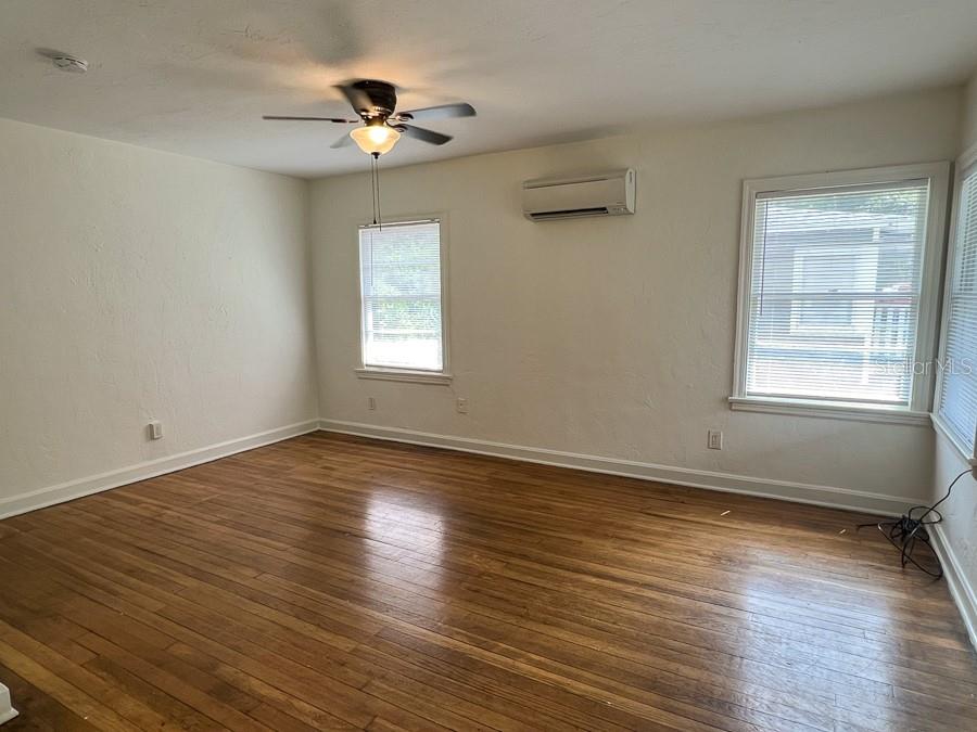 1124 Northwest 4th Avenue Gainesville, FL 32601 - Photo 8 of 16 a view of an empty room with wooden floor and a window