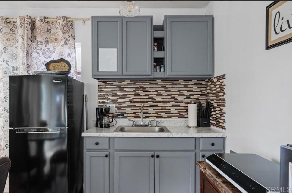 3964 Delta Street San Diego, CA 92113 - Photo 22 of 39 a kitchen with a refrigerator and a sink