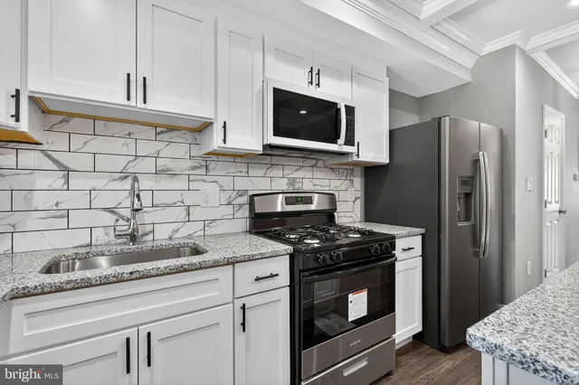 a kitchen with stainless steel appliances granite countertop a stove a microwave and a refrigerator