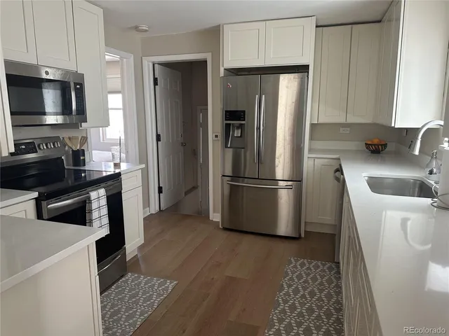 a kitchen with stainless steel appliances a refrigerator a sink a stove a microwave and cabinets