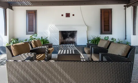a living room with furniture a fireplace and a floor to ceiling window