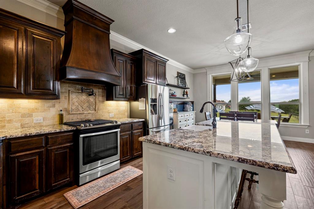 2103 Cash Point Court Granbury, TX 76049 - Photo 10 of 38 a kitchen with stainless steel appliances granite countertop a stove a sink and a microwave