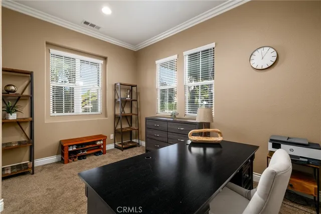 a view of a workspace with furniture and a window