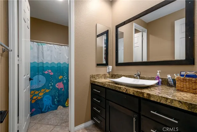 a bathroom with a granite countertop sink and a mirror
