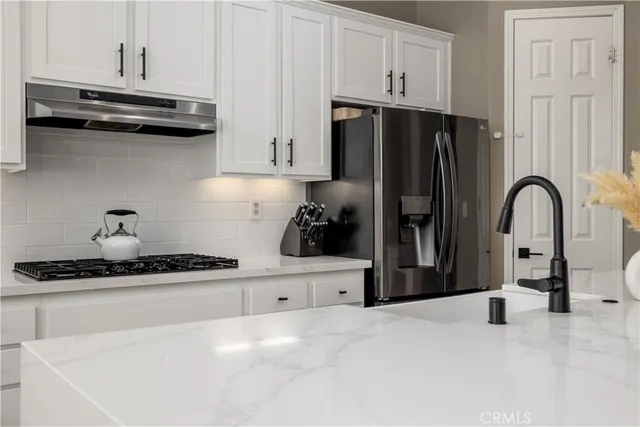 a kitchen with stainless steel appliances granite countertop a refrigerator and a stove