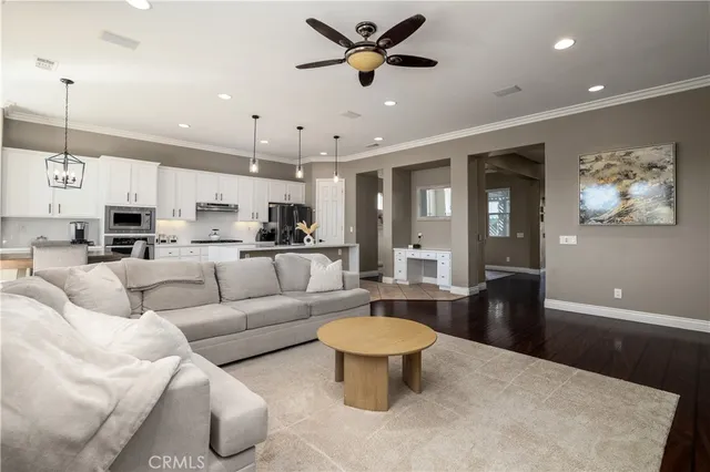 a living room with furniture a kitchen view and a chandelier
