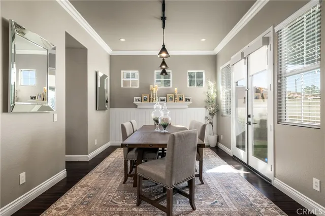 a dining room with furniture a chandelier and wooden floor