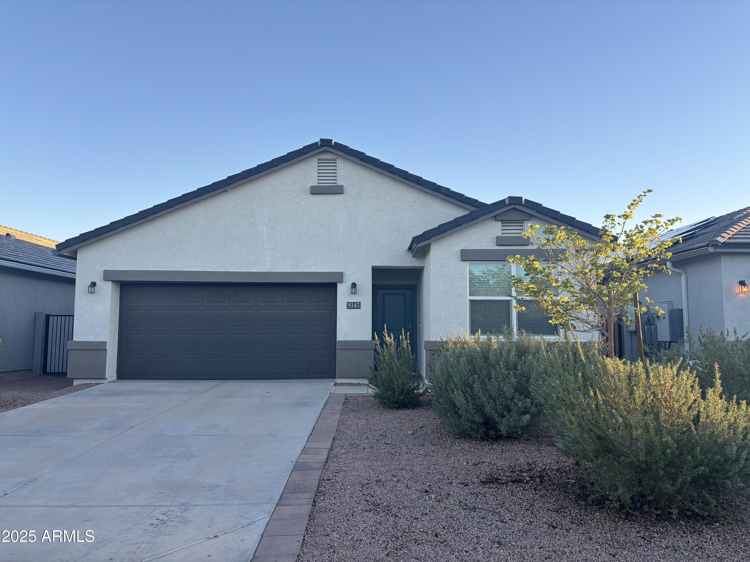 9345 Greenhouse Road Florence, AZ 85132 - Photo 1 of 13 a front view of a house with a yard and garage
