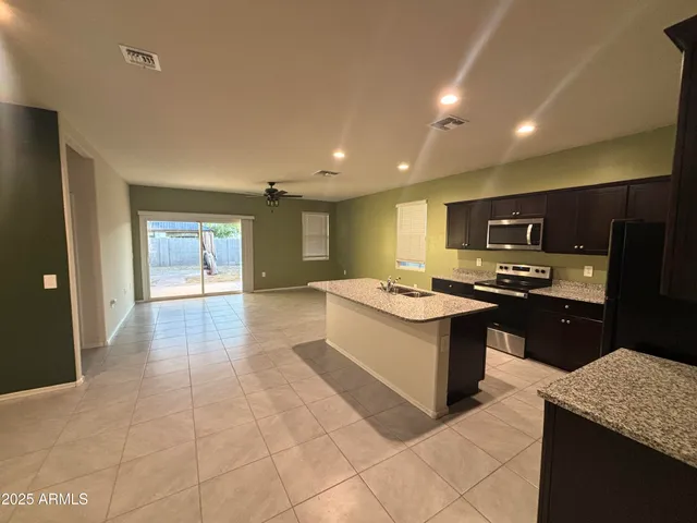 a large kitchen with stainless steel appliances granite countertop a sink and cabinets