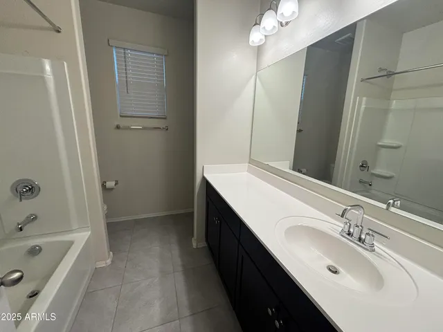 a bathroom with a tub sink and mirror