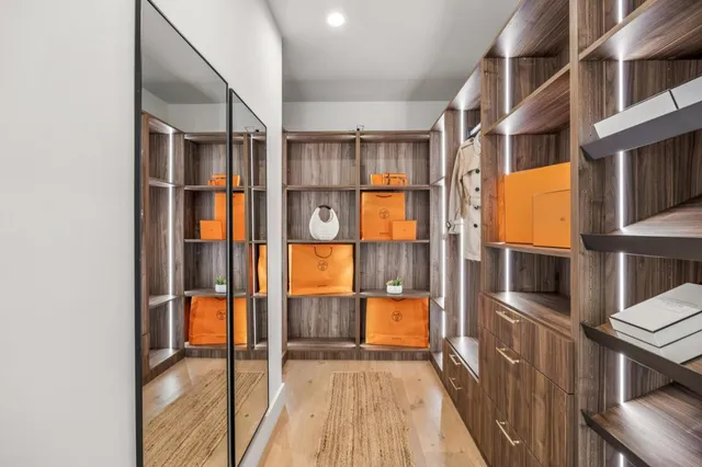 an aerial view of a house with large trees and lawn chairs