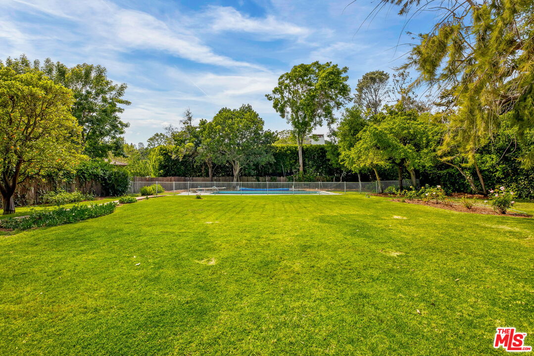 1639 Mandeville Canyon Road Los Angeles, CA 90049 - Photo 7 of 10 a view of outdoor space with swimming pool and green space