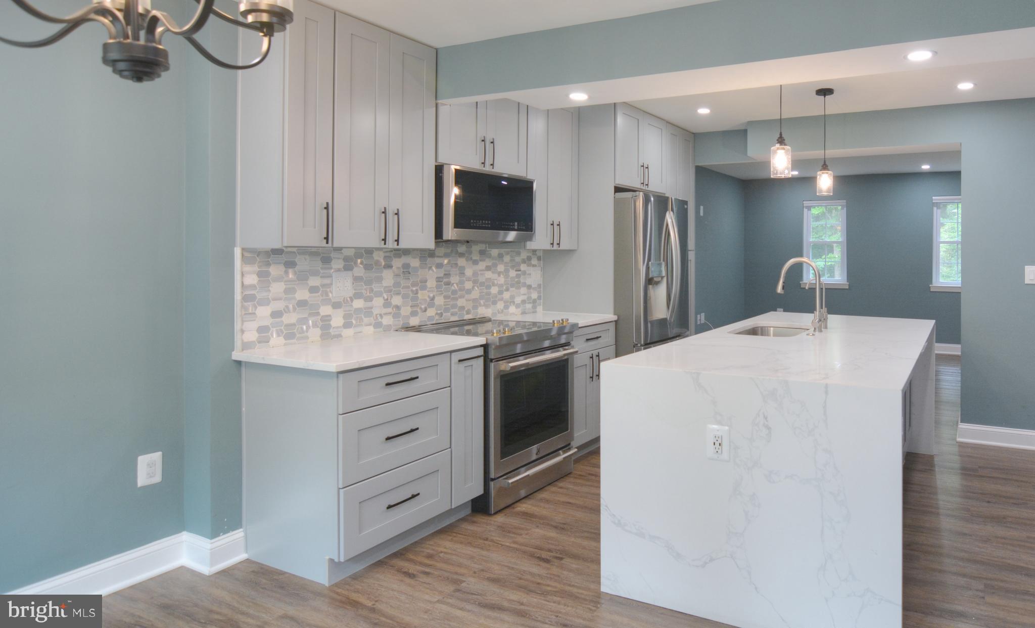 3822 Gawayne Terrace, Unit 32382 Silver Spring, MD 20906 - Photo 11 of 32 a kitchen with kitchen island white cabinets and stainless steel appliances