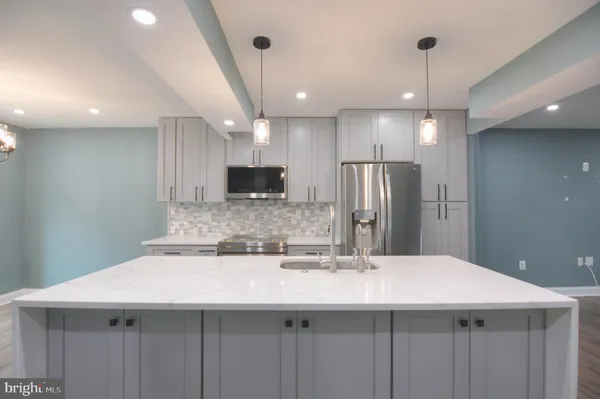 a kitchen with kitchen island a sink stainless steel appliances and refrigerator