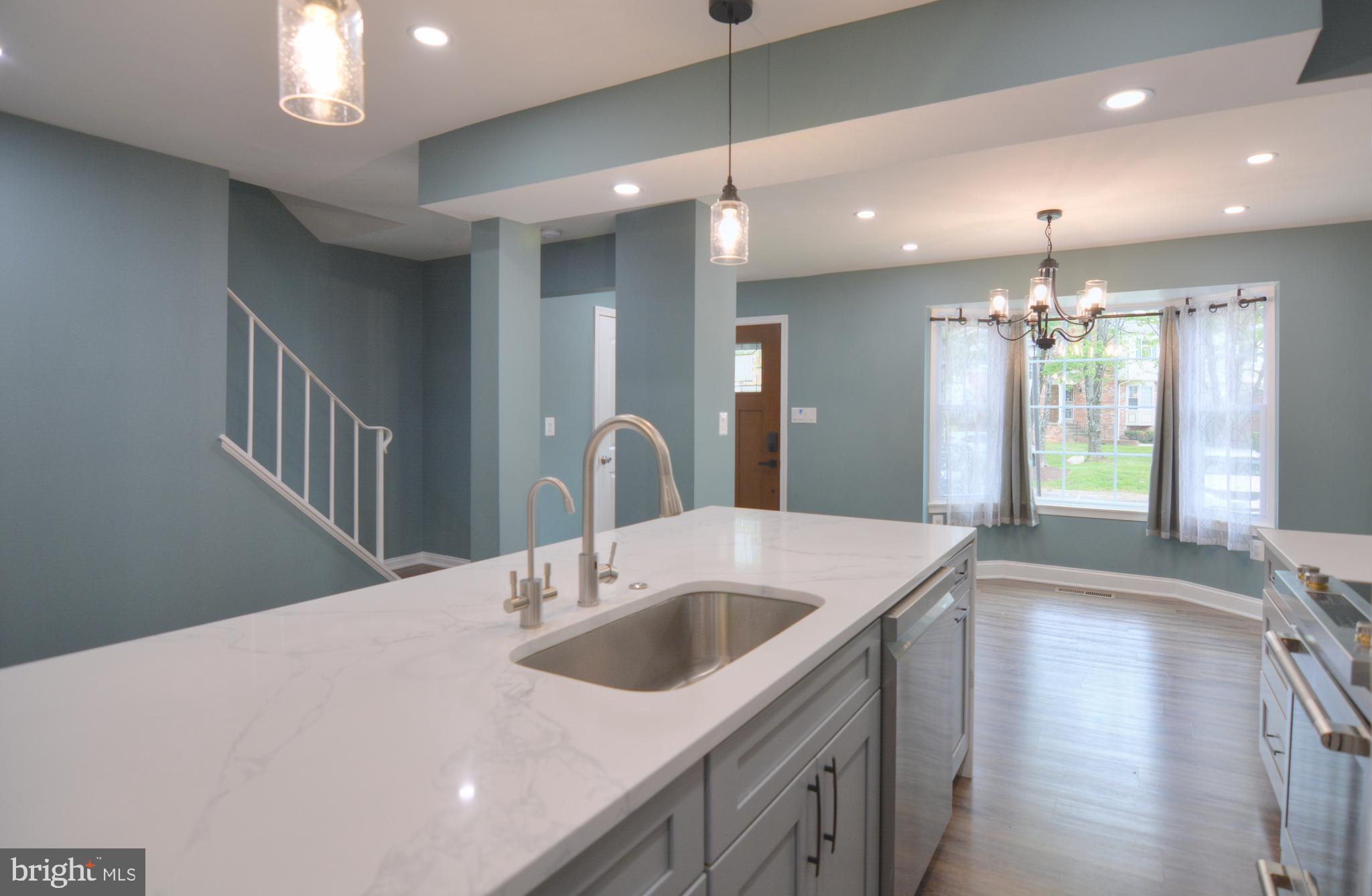3822 Gawayne Terrace, Unit 32382 Silver Spring, MD 20906 - Photo 16 of 32 a kitchen with a sink chandelier and wooden floor