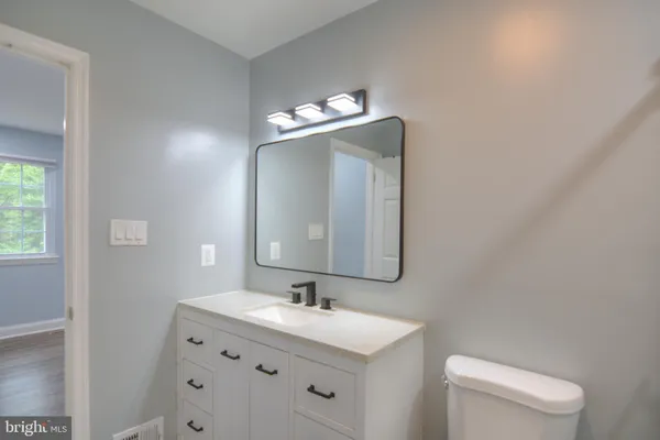 a bathroom with a toilet sink and mirror