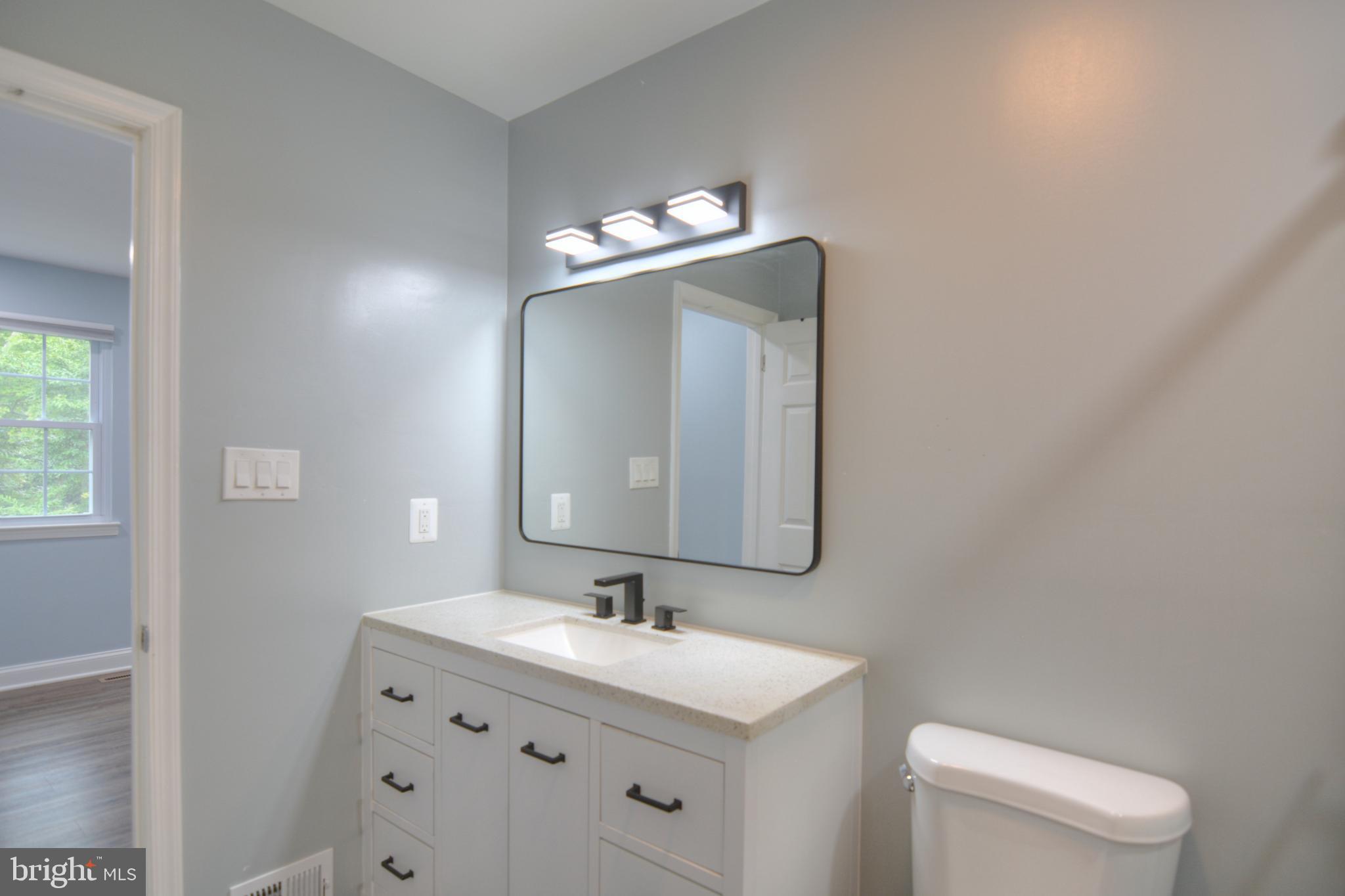 3822 Gawayne Terrace, Unit 32382 Silver Spring, MD 20906 - Photo 26 of 32 a bathroom with a toilet sink and mirror