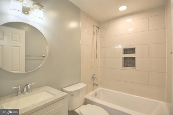 a bathroom with a granite countertop sink a toilet and shower