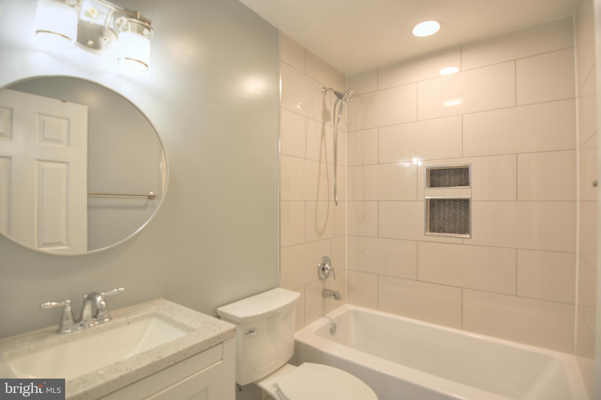 3822 Gawayne Terrace, Unit 32382 Silver Spring, MD 20906 - Photo 31 of 32 a bathroom with a granite countertop sink a toilet and shower