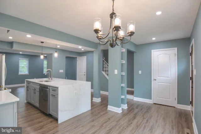 a view of a hallway with wooden floor and chandelier