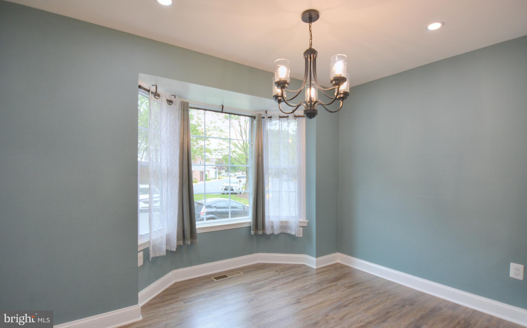 3822 Gawayne Terrace, Unit 32382 Silver Spring, MD 20906 - Photo 9 of 32 an empty room with wooden floor and windows
